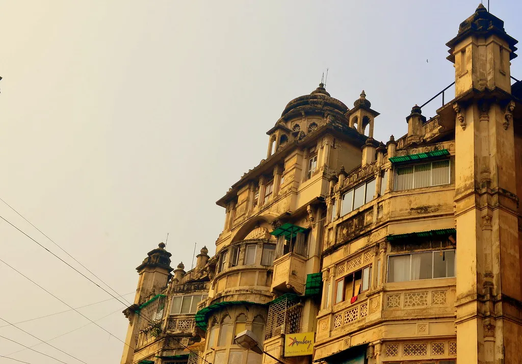 An ornate old apartment building with domed towers and balconies in Kolkata